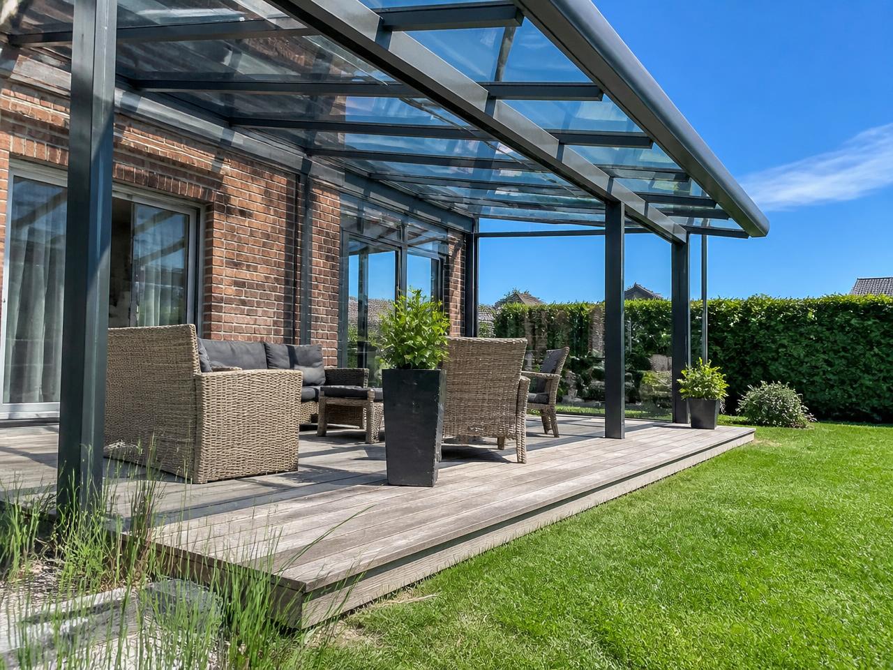 Moderne veranda met glazen dak bij een woning op een zonnige dag